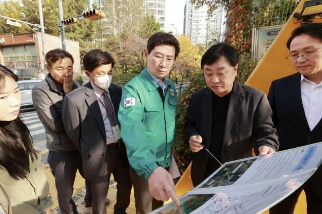 지난해 11월 이상일 용인특례시장이 상현초등학교를 방문해 협소한 정문 앞 대기 장소 개선 방안을 관계자들의 논의하고 있는 모습
