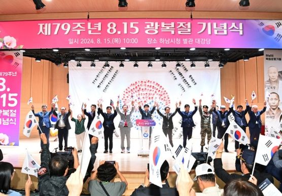15일 열린 제79주년 광복절 기념식에서 참가자들이 태극기를 들고 만세삼창을 하고 있다.