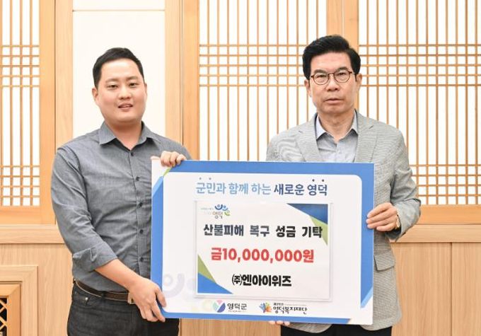 ㈜엔아이위즈가 김광열 영덕군수를 만나 성금을 전달하고 있다.