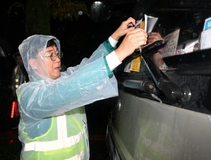 이민근 안산시장이 지난해 10월 대형자동차 불법주청자 현장계도에 나서 직접 차량에 단속 계도물을 부착하고 있다.
